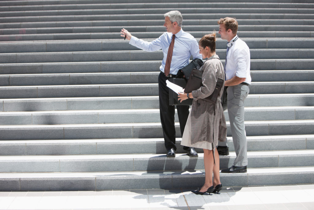 Photo of people looking up stairs and getting ready to go