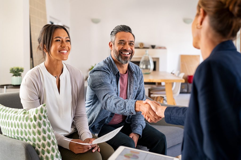 Couple happily shaking hands with Financial Adviser after satisfactory Insurance Review